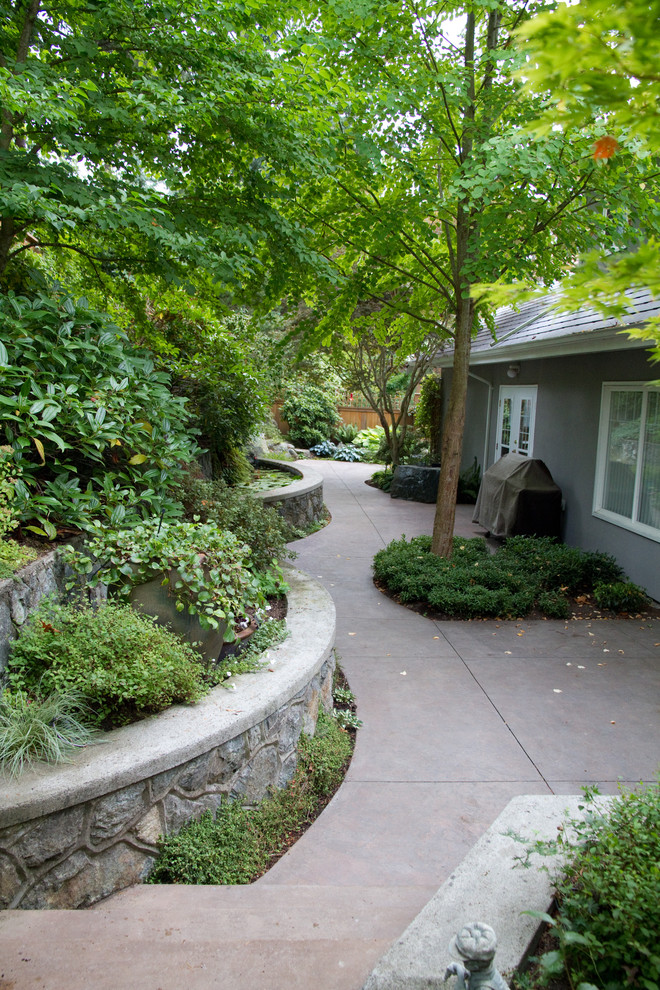 На фото: двор среднего размера на заднем дворе в современном стиле с фонтаном и покрытием из декоративного бетона