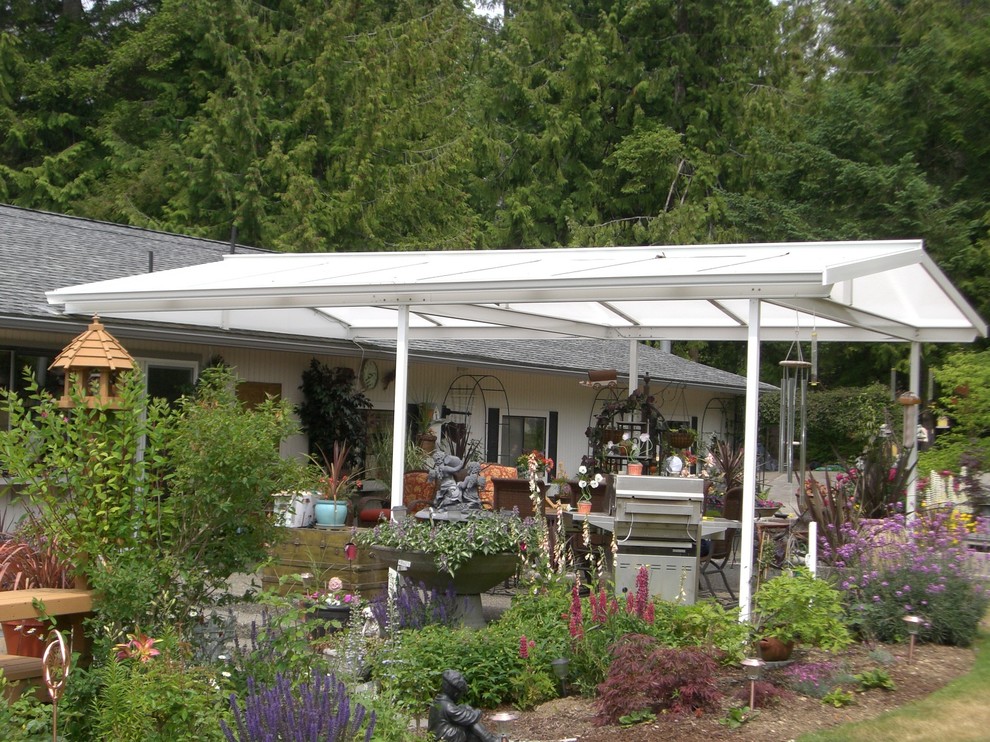 Design ideas for a medium sized country back patio in Seattle with an outdoor kitchen, concrete slabs and an awning.
