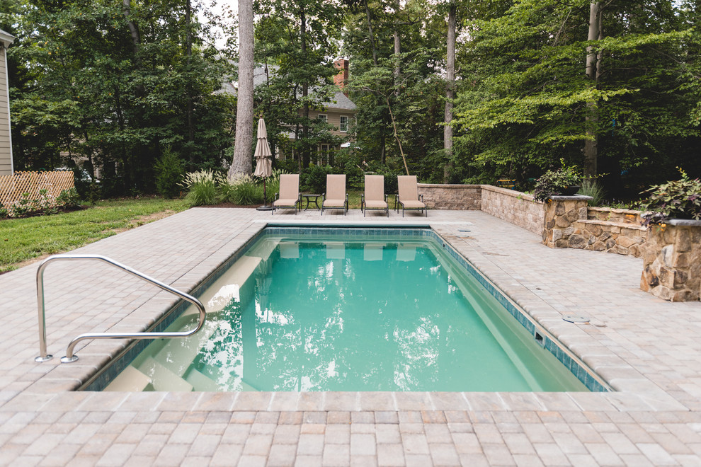 Foto di una piscina tradizionale di medie dimensioni e dietro casa con fontane e pavimentazioni in mattoni