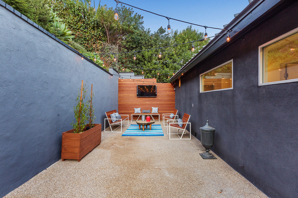 Ispirazione per un patio o portico minimal dietro casa con lastre di cemento e nessuna copertura