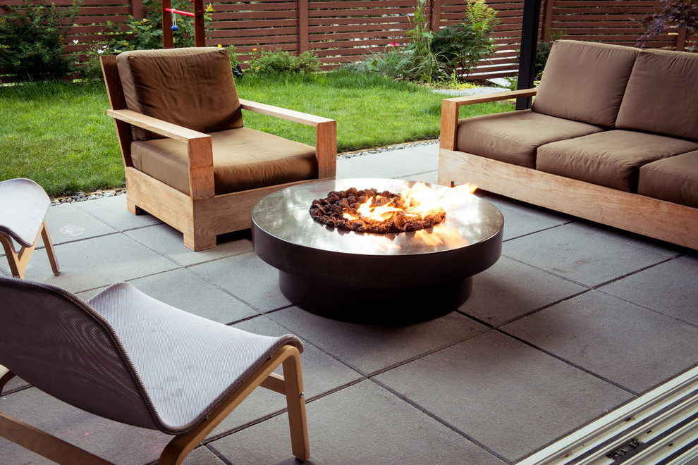 Example of a mid-sized trendy backyard concrete paver patio design in Vancouver with a fire pit and no cover