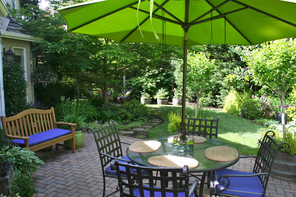 Diseño de patio clásico en patio trasero con adoquines de ladrillo