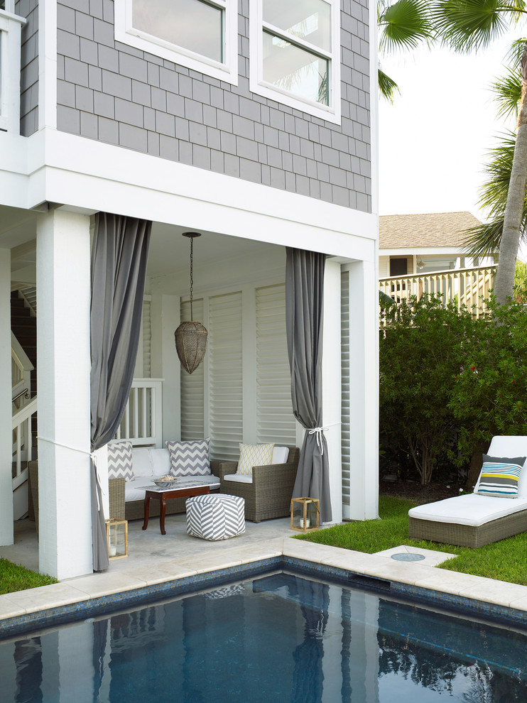 Esempio di un patio o portico stile marino dietro casa con pavimentazioni in pietra naturale e un tetto a sbalzo
