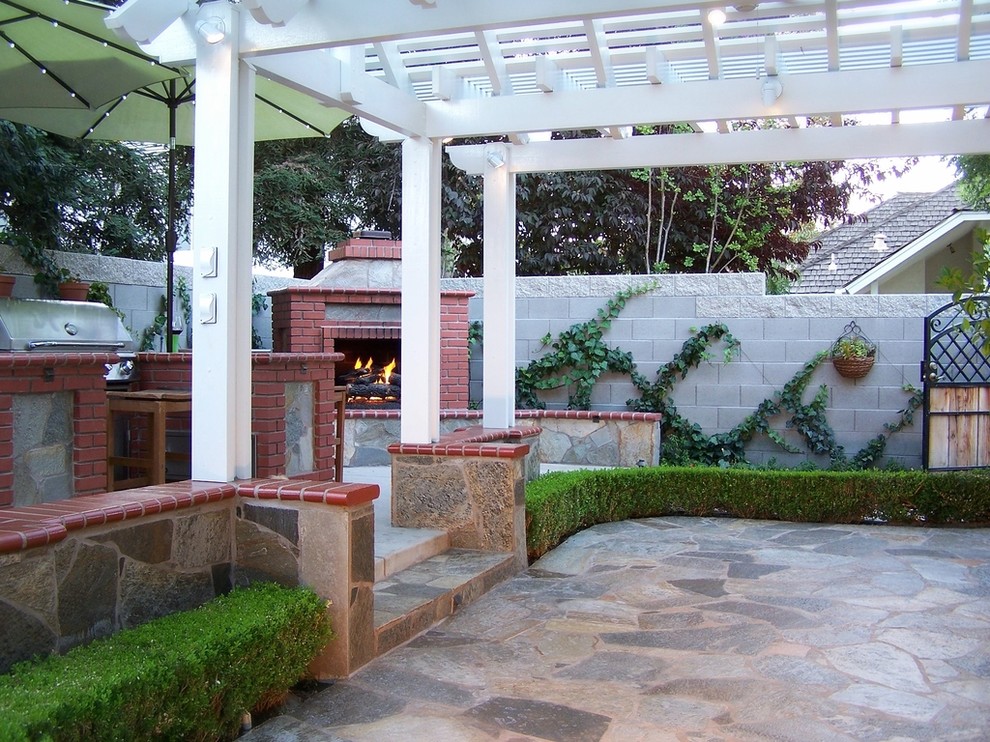 Idee per un grande patio o portico minimal dietro casa con pavimentazioni in pietra naturale e una pergola