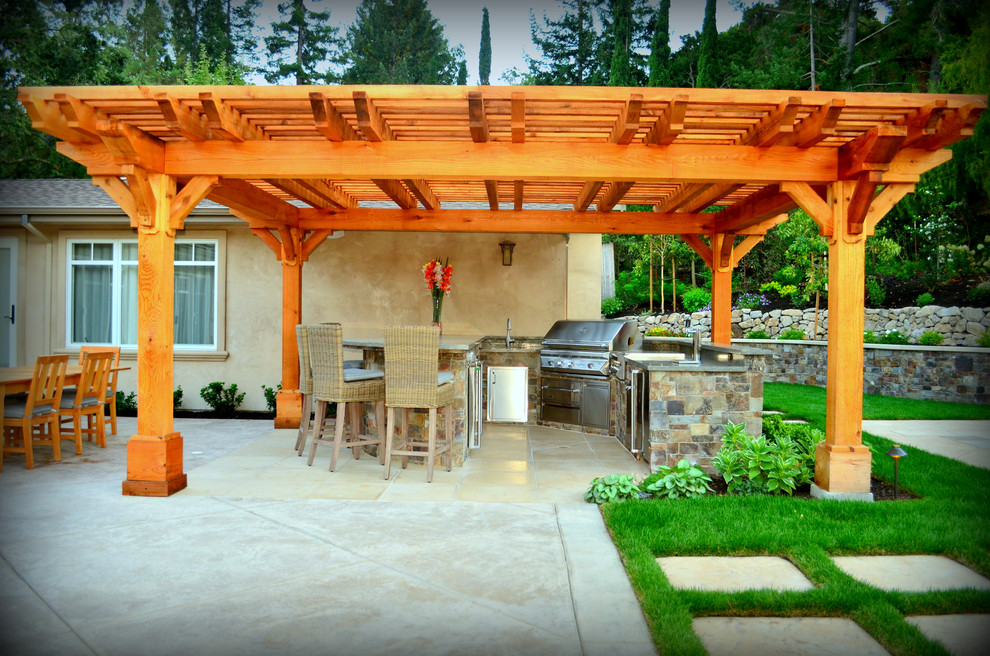 Foto de patio clásico renovado grande en patio trasero con cocina exterior, losas de hormigón y pérgola