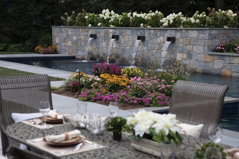 Cette photo montre une très grande terrasse arrière tendance avec une cuisine d'été, des pavés en pierre naturelle et aucune couverture.