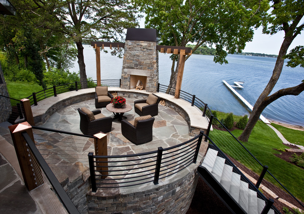 Foto de patio marinero de tamaño medio en patio trasero con brasero, pérgola y adoquines de piedra natural