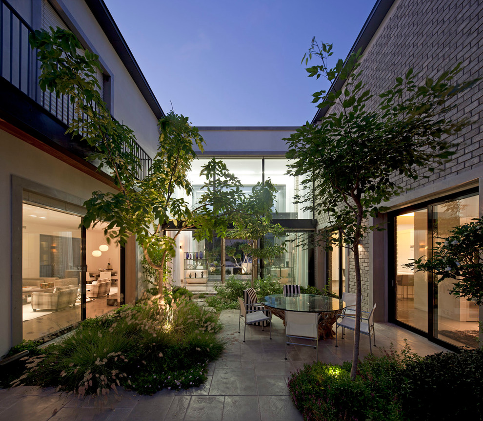 Стильный дизайн: большой двор на заднем дворе в стиле модернизм с покрытием из каменной брусчатки - последний тренд