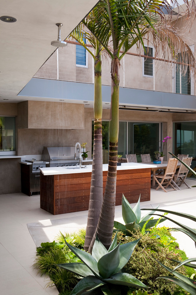 Großer, Überdachter Patio hinter dem Haus mit Outdoor-Küche und Betonplatten in Los Angeles
