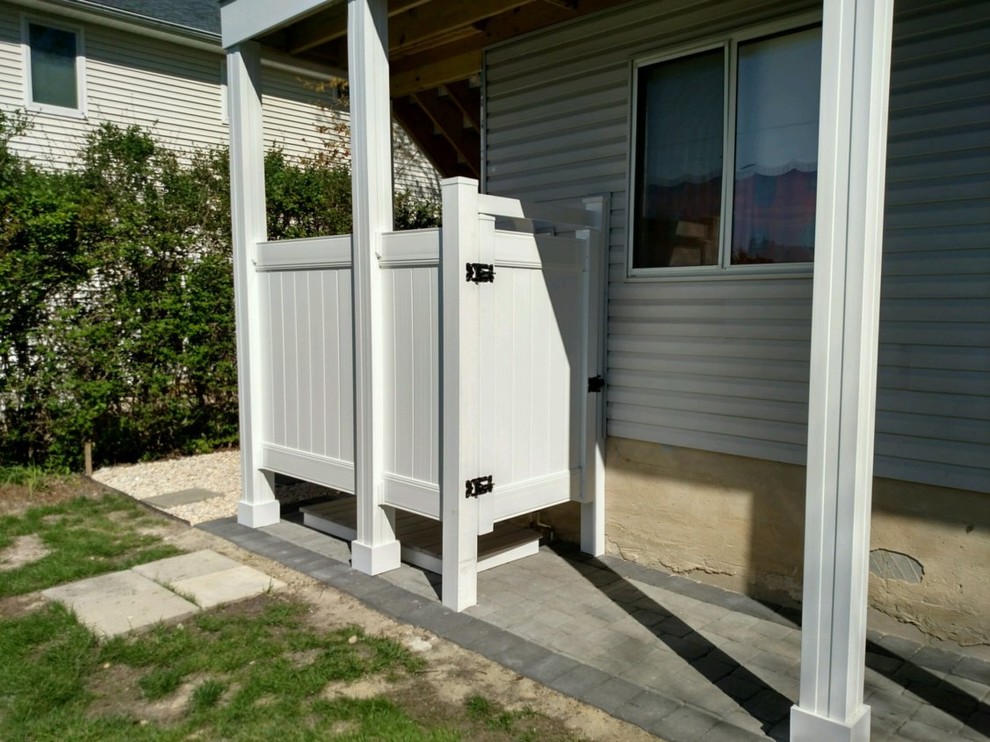 This is an example of a medium sized classic side patio in Other with an outdoor shower, concrete paving and no cover.