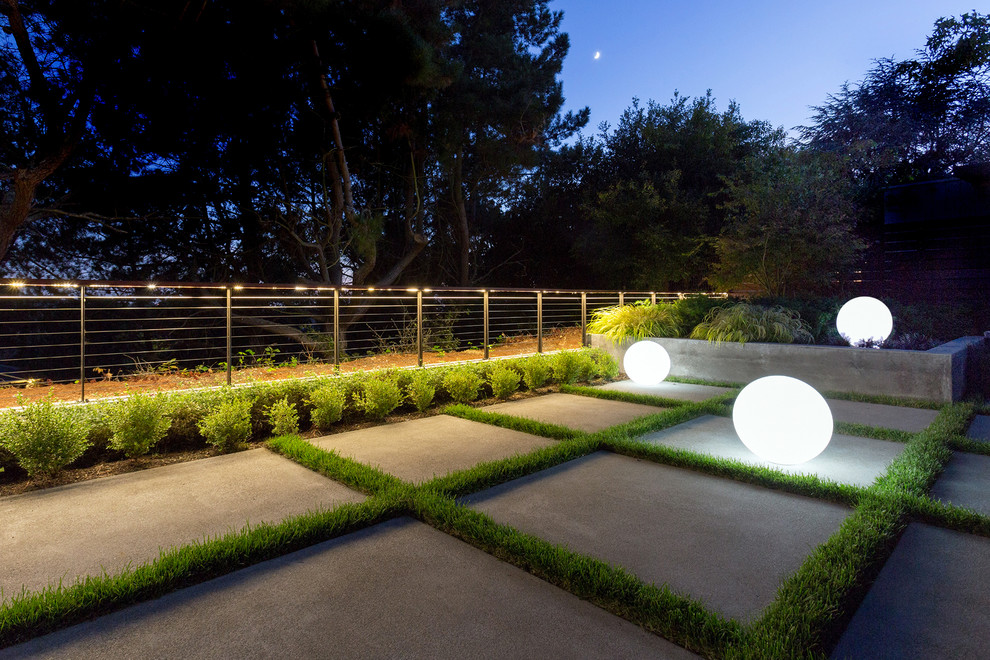Modelo de patio moderno de tamaño medio sin cubierta en patio trasero con jardín de macetas y adoquines de hormigón