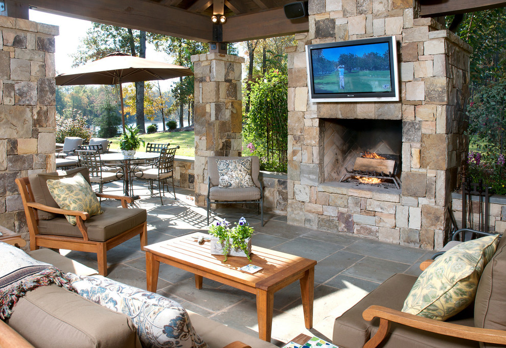 Inspiration for a mid-sized timeless backyard stone patio remodel in Atlanta with a fire pit and a roof extension