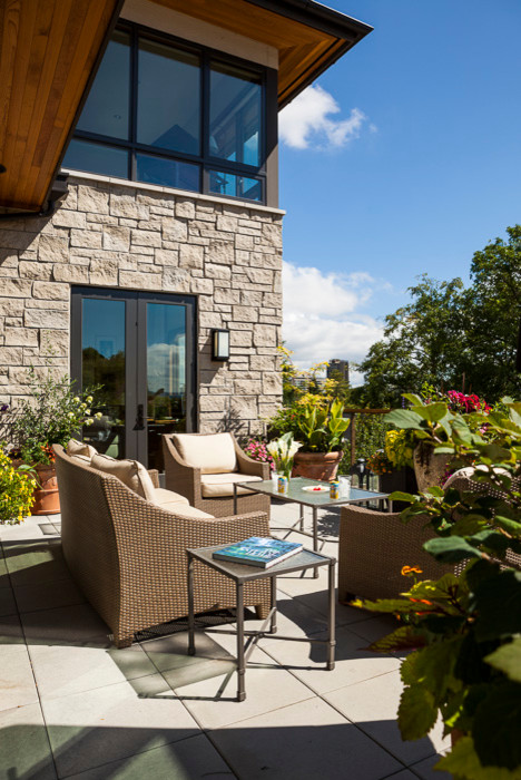 Imagen de patio actual de tamaño medio sin cubierta en patio delantero con jardín de macetas y adoquines de hormigón