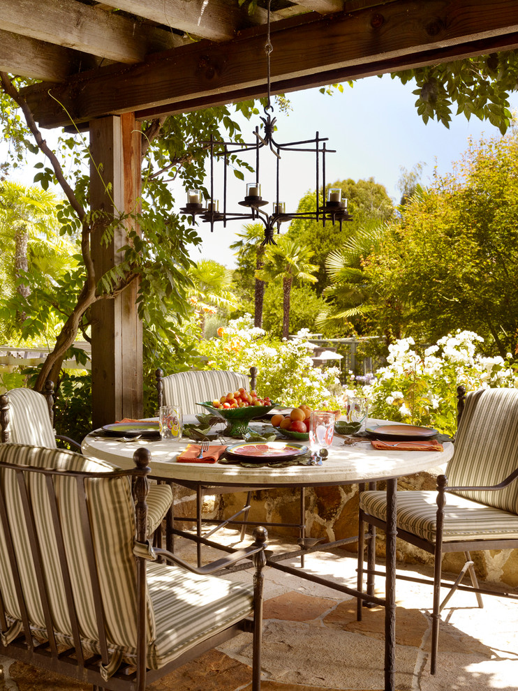 Foto de patio mediterráneo con adoquines de piedra natural, pérgola y cocina exterior