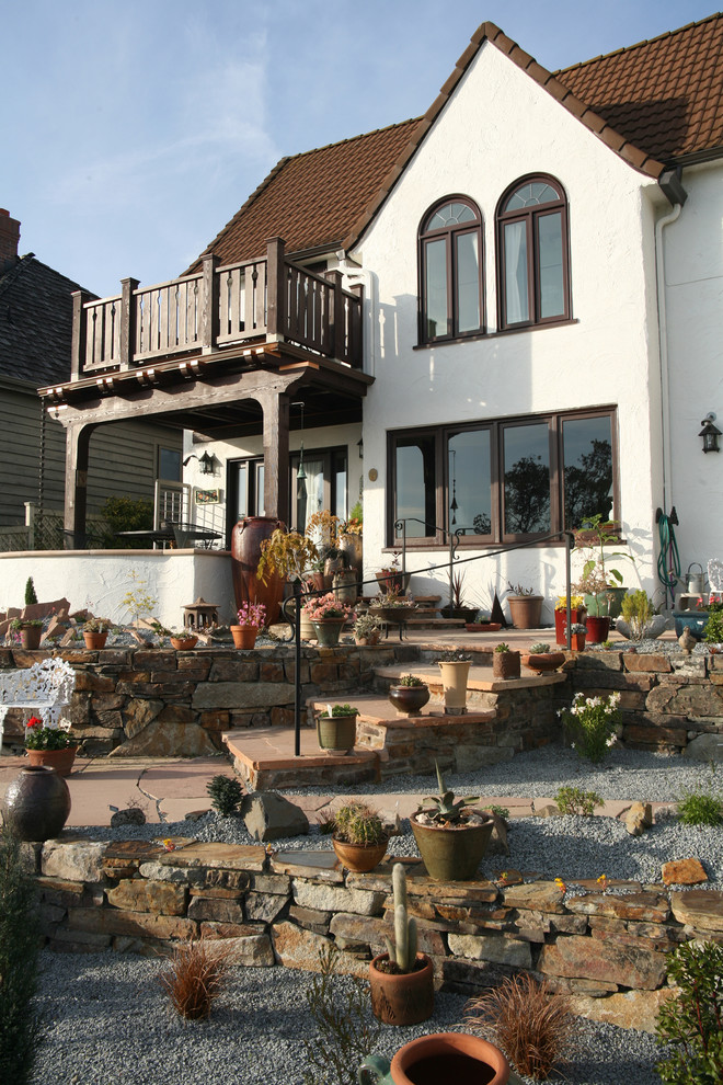 Diseño de patio clásico de tamaño medio en patio trasero con jardín de macetas y adoquines de piedra natural