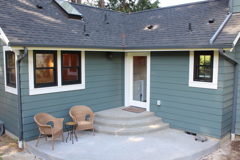Ejemplo de patio de estilo americano de tamaño medio sin cubierta en patio trasero con losas de hormigón