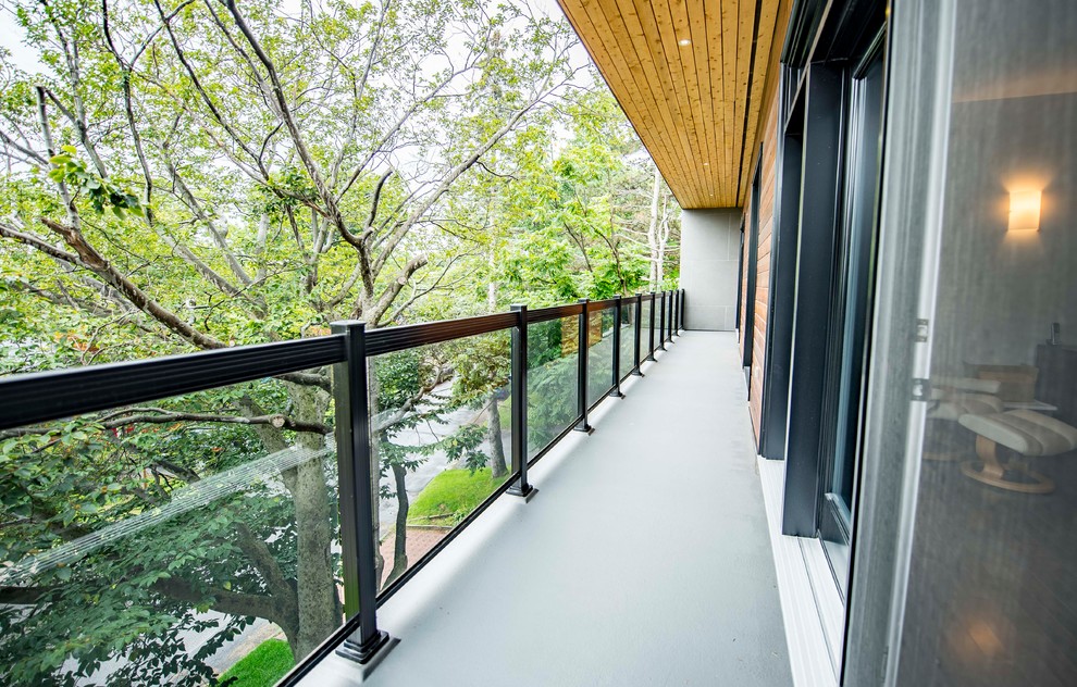 Idée de décoration pour une terrasse avant design avec une dalle de béton et une extension de toiture.