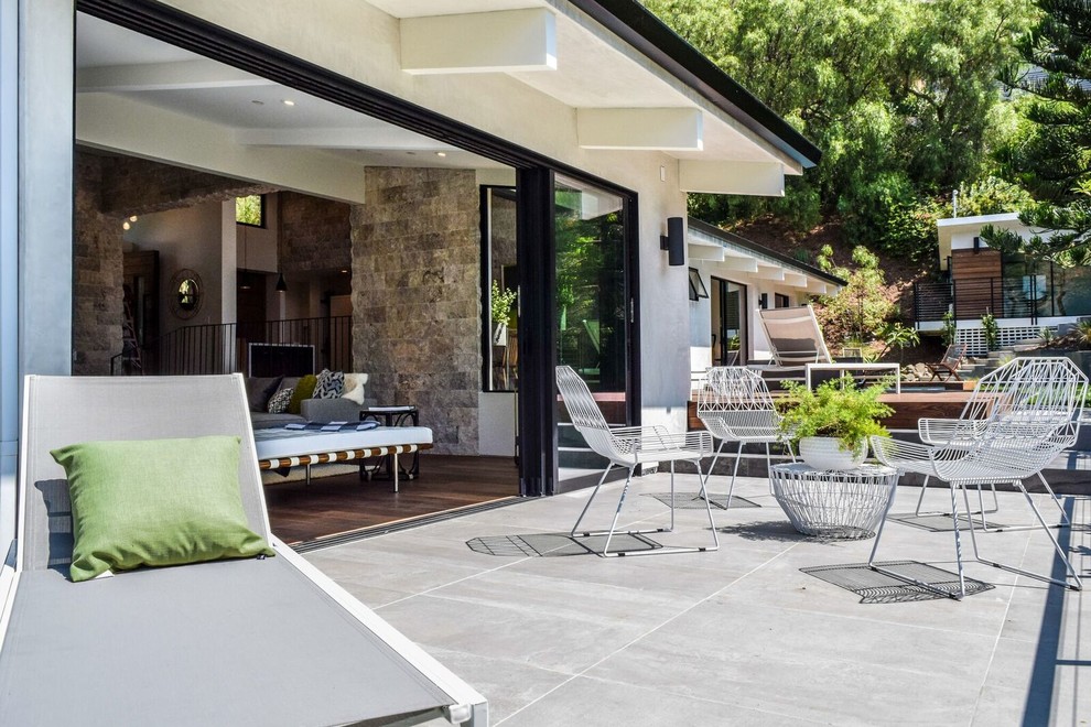 Ispirazione per un patio o portico minimalista di medie dimensioni e dietro casa con un focolare, pedane e nessuna copertura