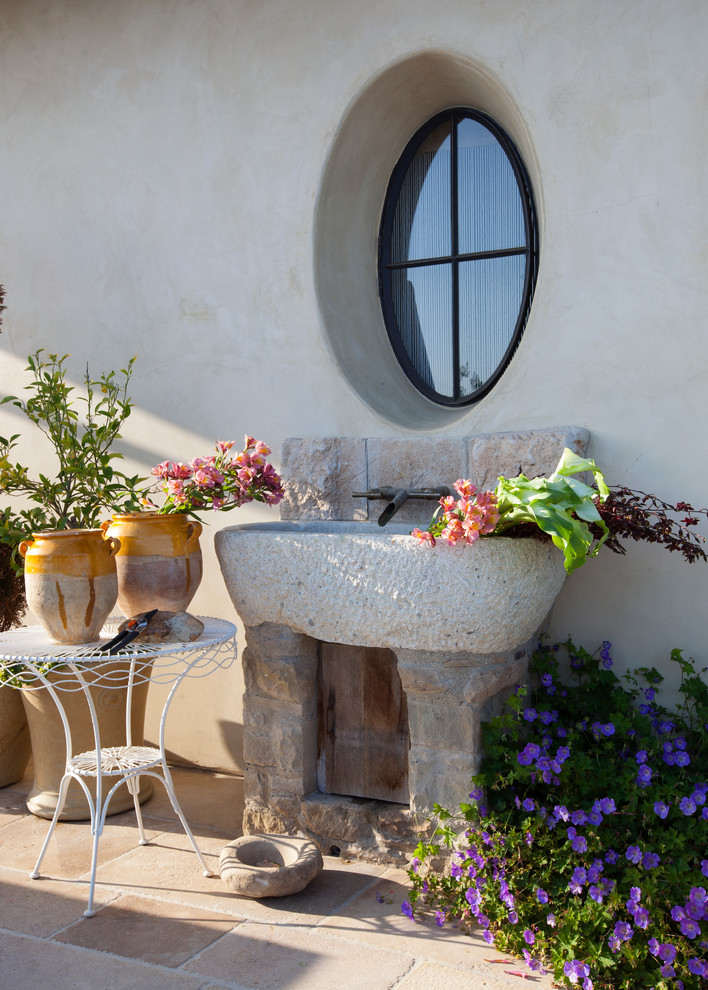 На фото: двор среднего размера на боковом дворе в средиземноморском стиле с покрытием из каменной брусчатки без защиты от солнца с