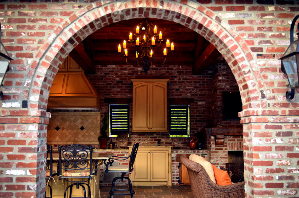Inspiration for a large industrial back patio in New Orleans with an outdoor kitchen, brick paving and a gazebo.