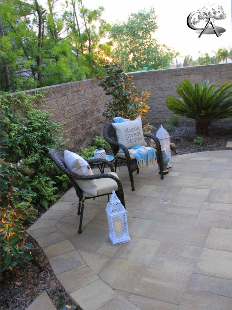 This is an example of a medium sized classic side patio in Orange County with a water feature and concrete paving.