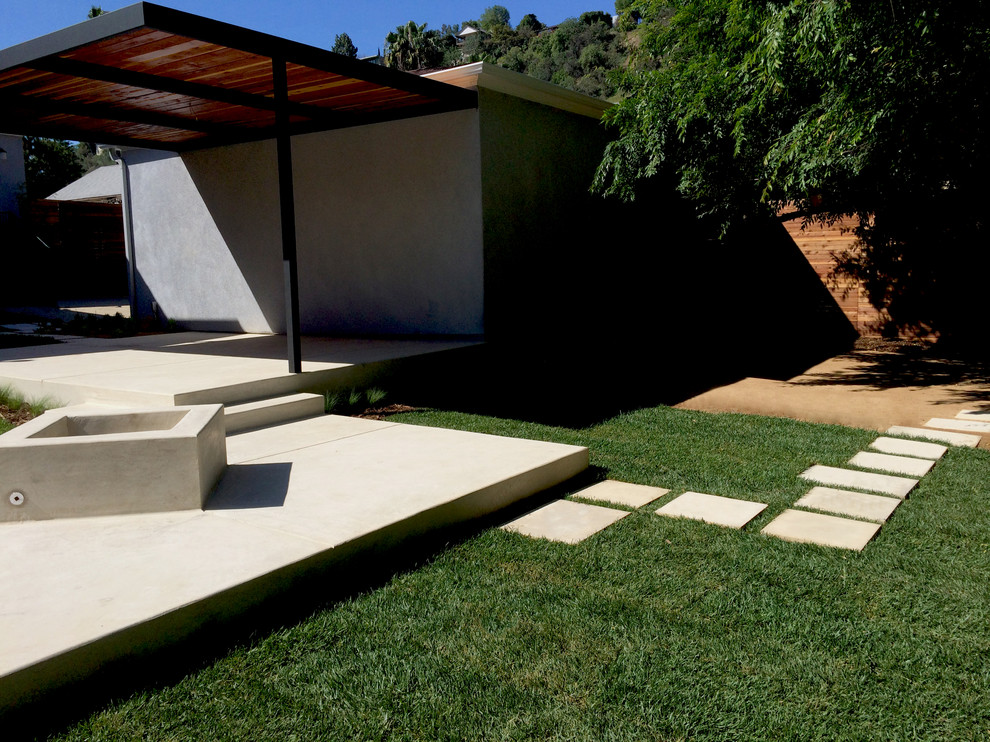 Example of a mid-sized trendy backyard concrete patio design in Los Angeles with a fire pit and a pergola