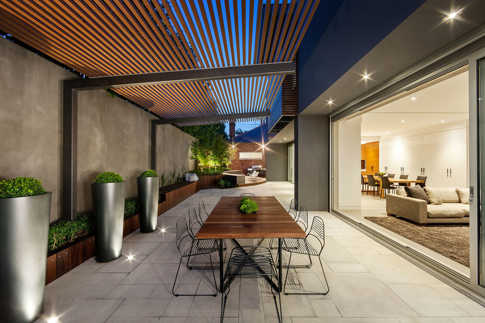 Immagine di un patio o portico design in cortile e di medie dimensioni con una pergola e un giardino in vaso