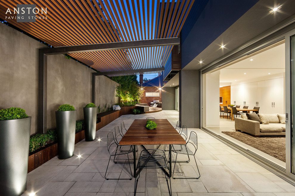 Example of a minimalist side yard concrete paver patio design in Melbourne with a pergola