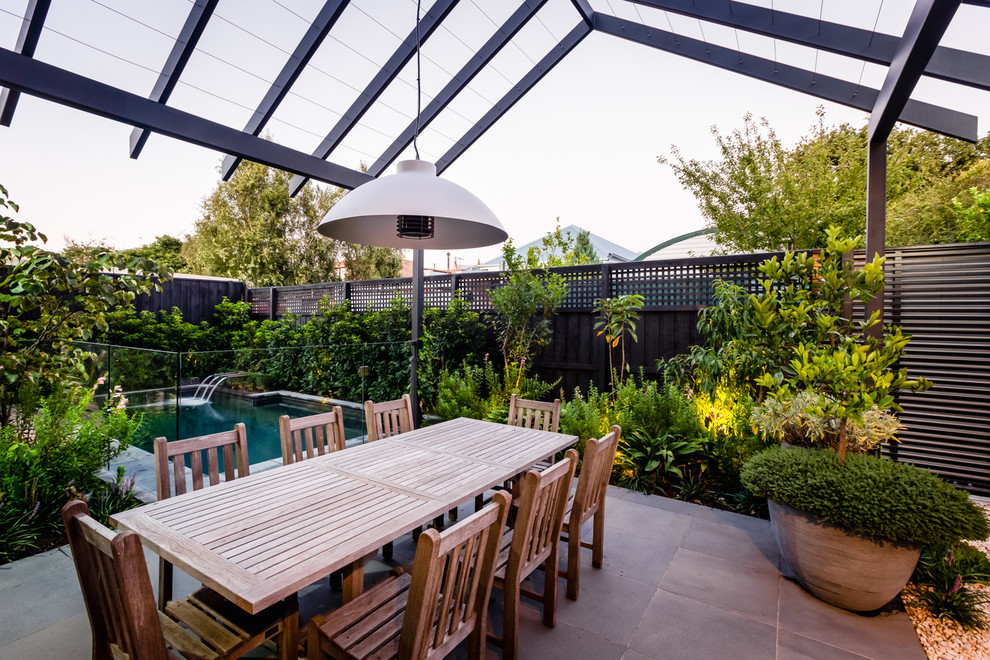 Cette image montre une terrasse arrière design avec une pergola.