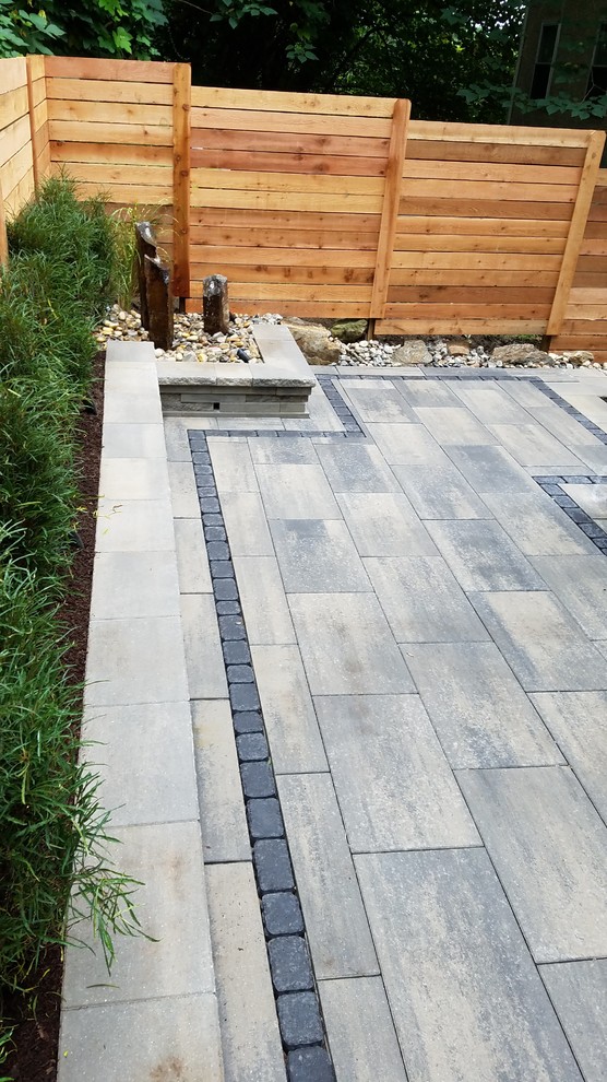 Medium sized modern back patio in Philadelphia with no cover and tiled flooring.