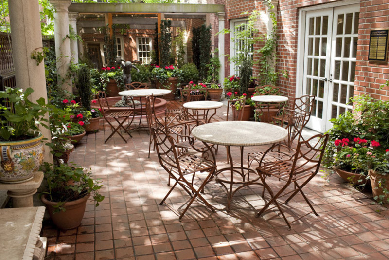 Photo of a classic courtyard patio in New York with a potted garden and tiled flooring.