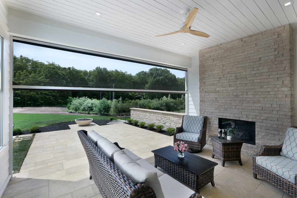 Foto di un patio o portico country di medie dimensioni e dietro casa con un caminetto, pavimentazioni in pietra naturale e un tetto a sbalzo