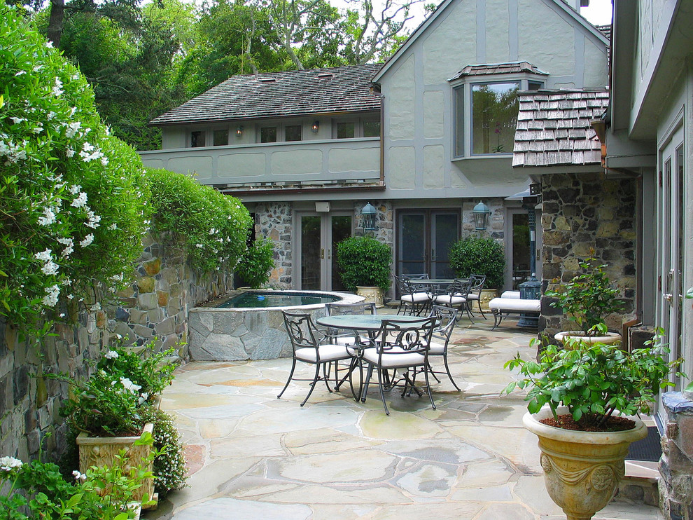 Esempio di un ampio patio o portico stile americano dietro casa con pavimentazioni in pietra naturale