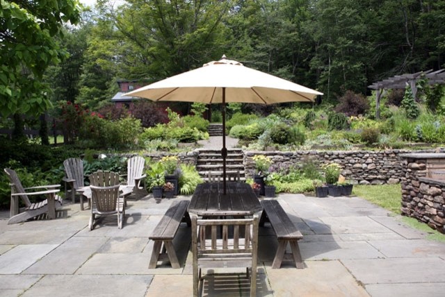 Inspiration for a large farmhouse back patio in New York with a potted garden, stamped concrete and no cover.