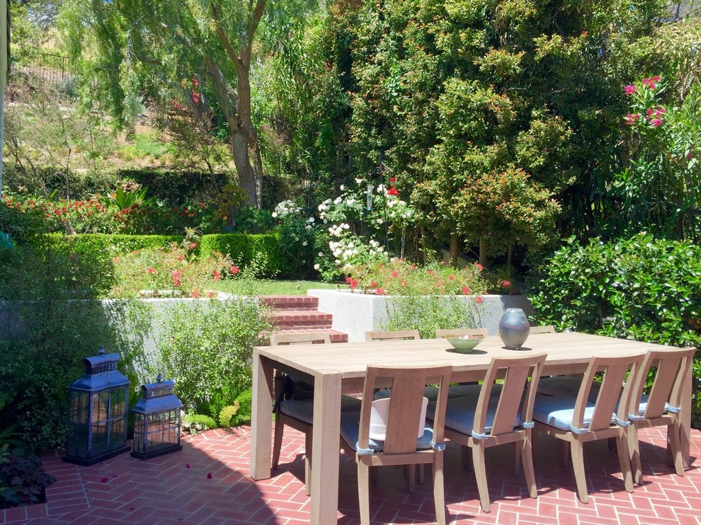 Inspiration for a mid-sized timeless backyard brick patio remodel in Los Angeles with no cover