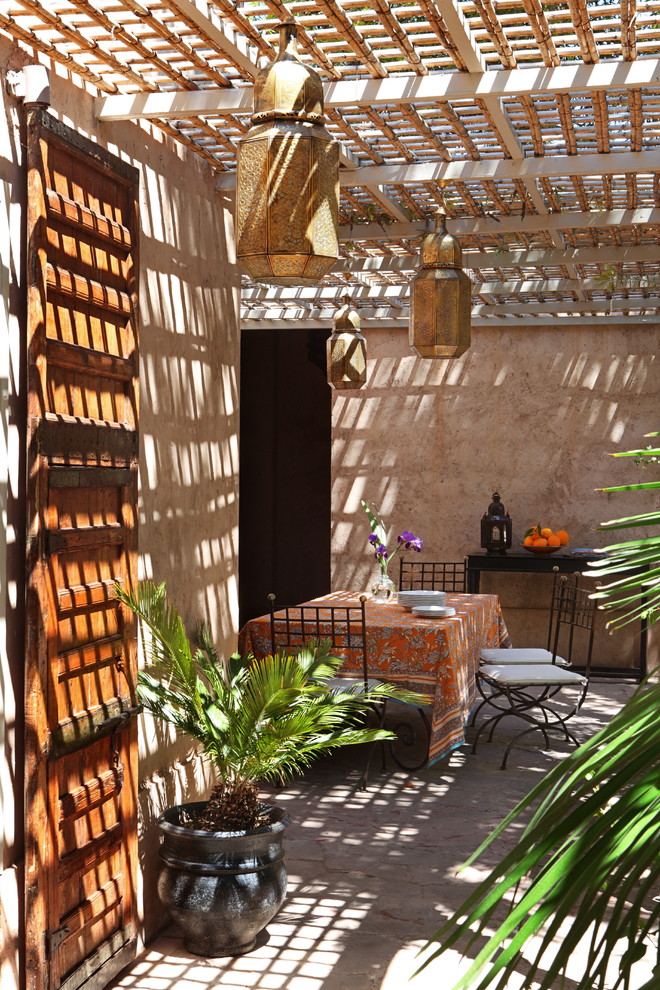 Идея дизайна: пергола во дворе частного дома на боковом дворе в средиземноморском стиле с растениями в контейнерах и покрытием из бетонных плит