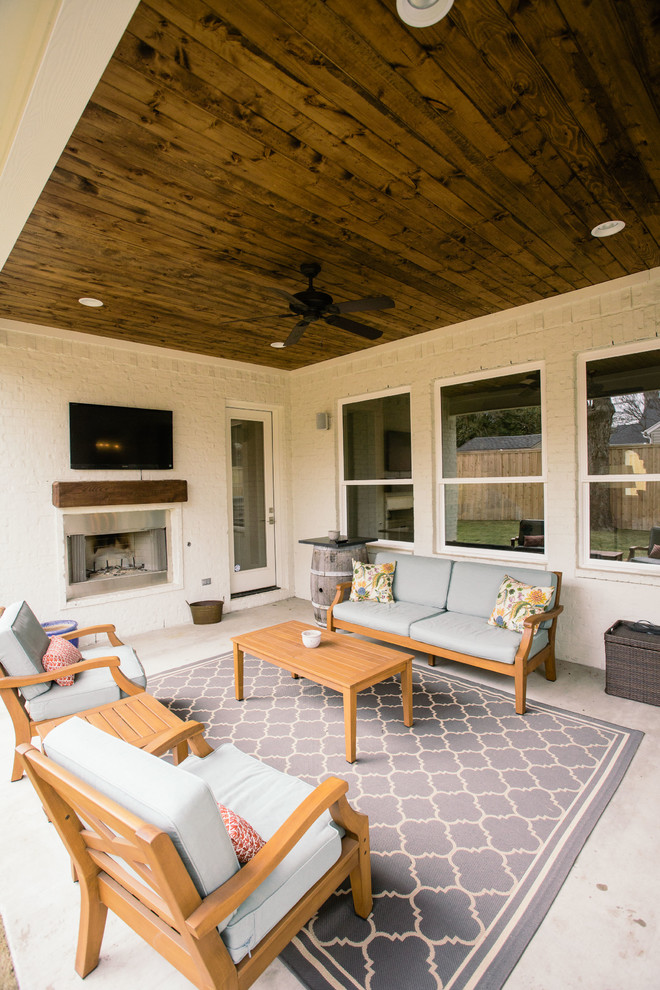 Überdachter Klassischer Patio hinter dem Haus mit Betonplatten und Kamin in Dallas