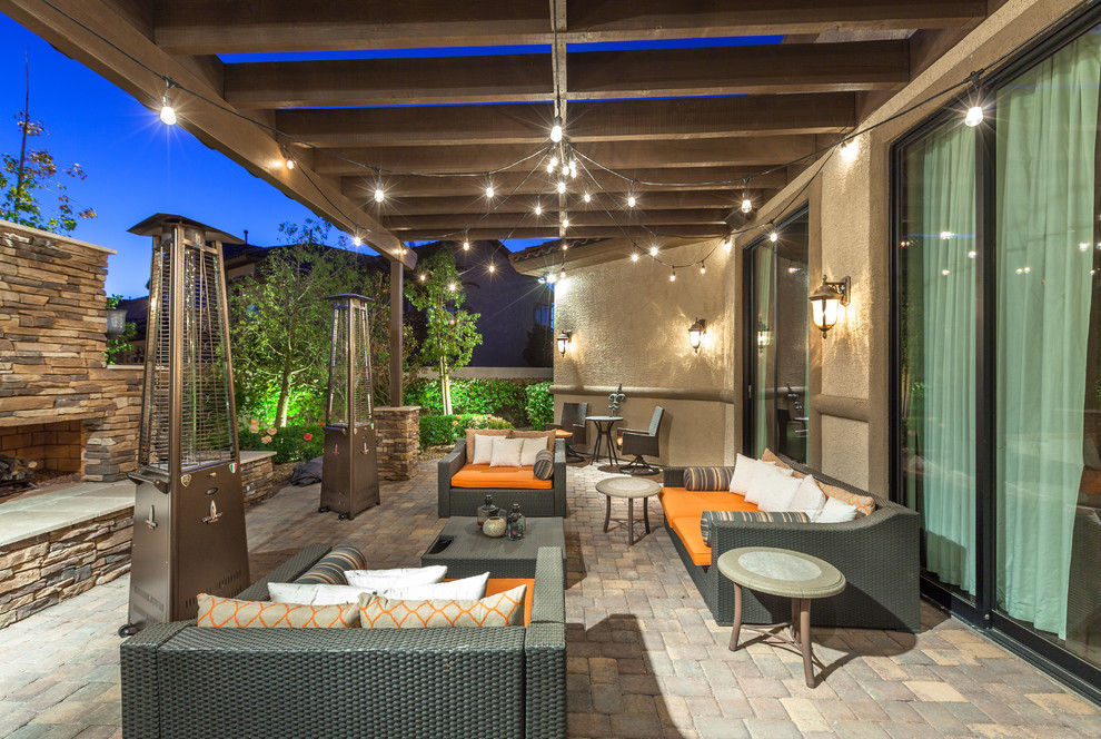 Mid-sized southwest side yard brick patio photo in Las Vegas with a pergola and a fire pit