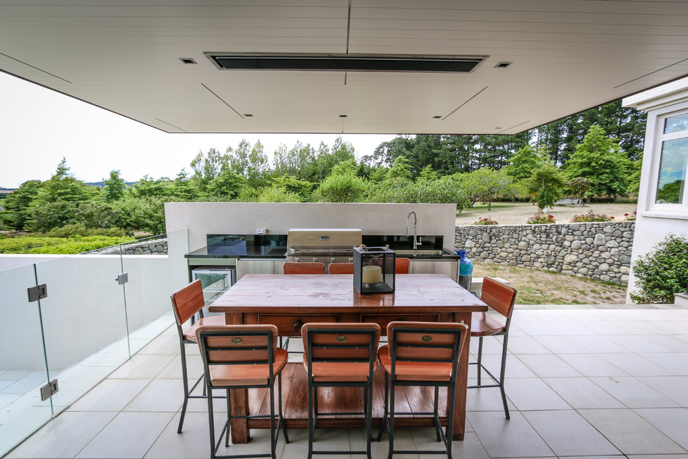 Idées déco pour une terrasse arrière contemporaine de taille moyenne avec une cuisine d'été, des pavés en béton et une extension de toiture.