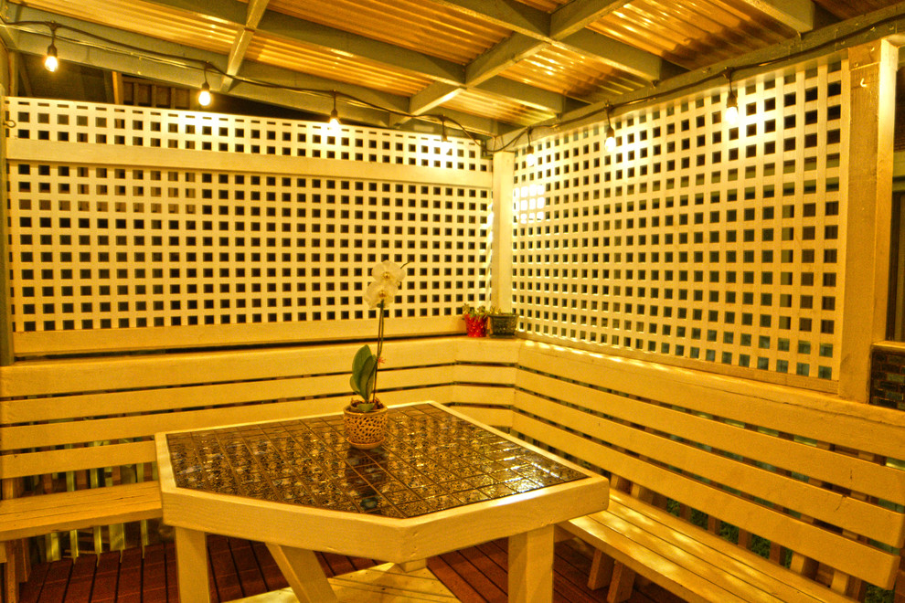 Modelo de patio tropical pequeño en patio trasero con cocina exterior, entablado y toldo