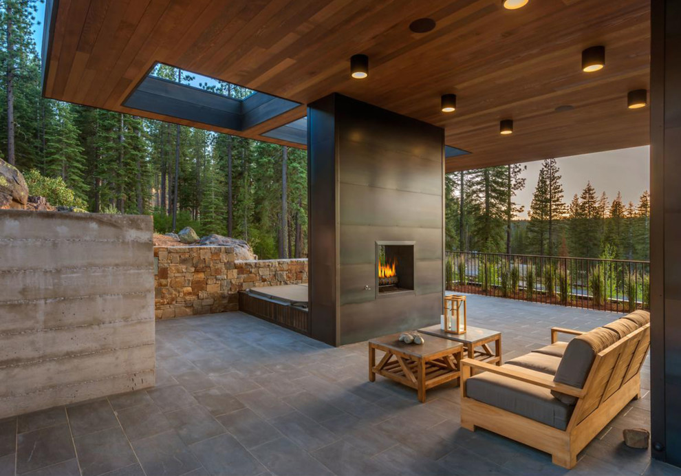Imagen de patio minimalista en anexo de casas con suelo de baldosas y chimenea