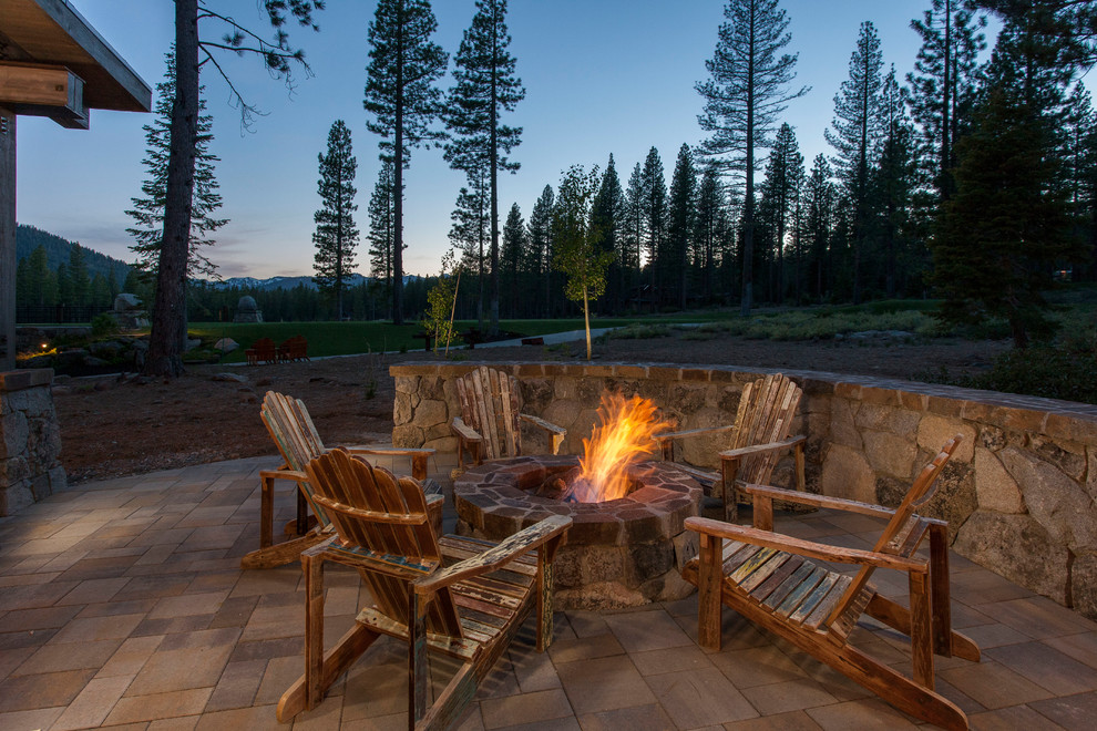 Photo of a rustic patio in Other with a fire feature and no cover.