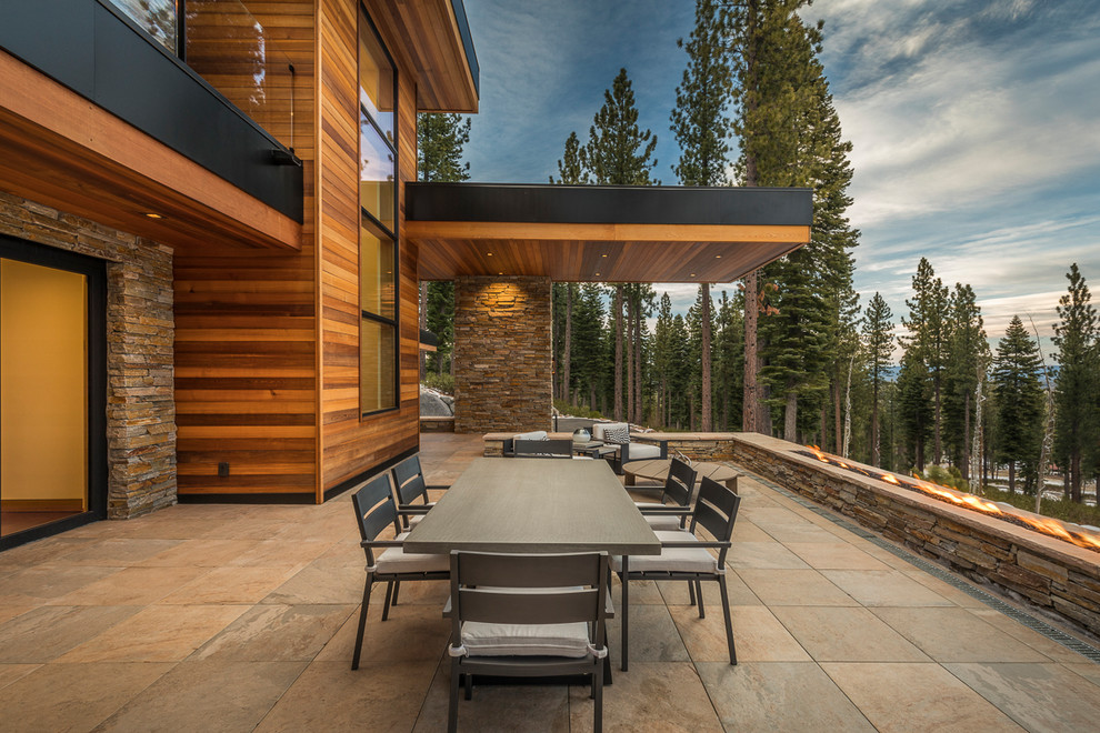 Réalisation d'une grande terrasse avant minimaliste avec une cuisine d'été, des pavés en pierre naturelle et aucune couverture.