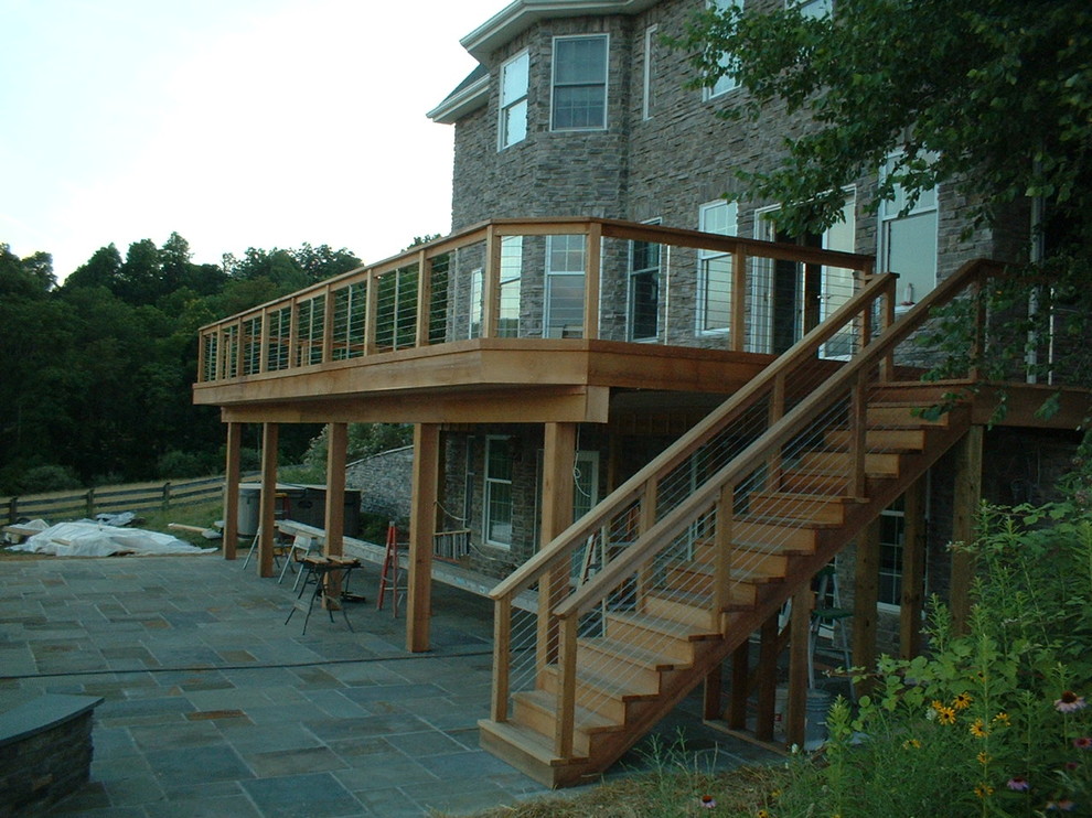 Example of a mountain style backyard stone patio design in Baltimore