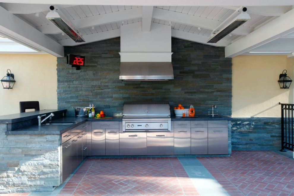 Réalisation d'une terrasse arrière tradition de taille moyenne avec une cuisine d'été, des pavés en brique et une extension de toiture.
