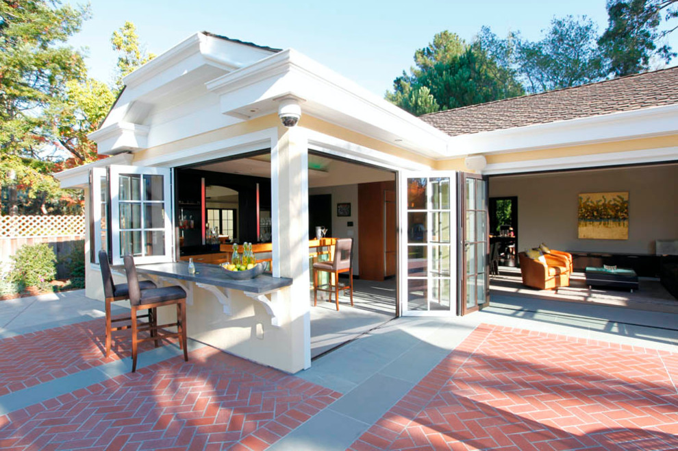 Modelo de patio tradicional renovado de tamaño medio sin cubierta en patio trasero con cocina exterior y adoquines de ladrillo