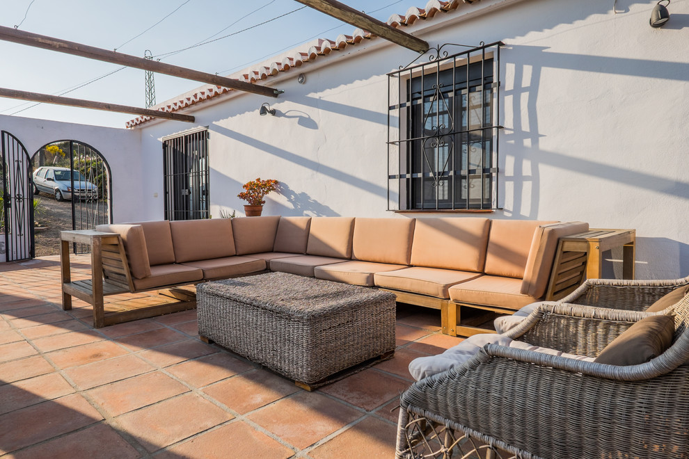Diseño de patio mediterráneo de tamaño medio en patio con suelo de baldosas y pérgola