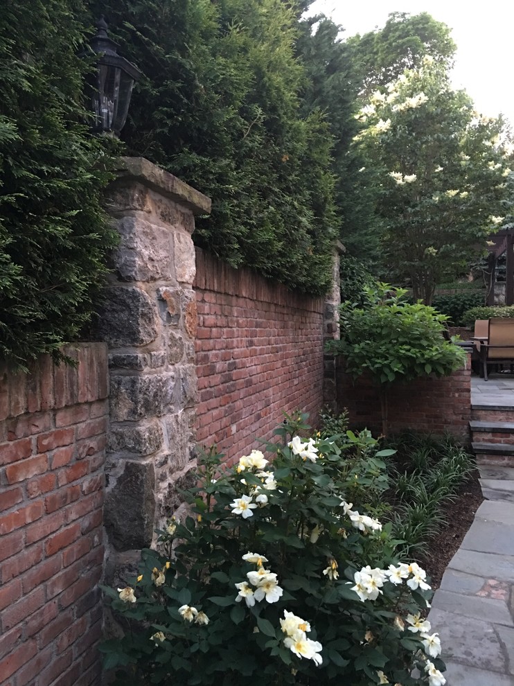 Mittelgroßer, Unbedeckter Uriger Patio hinter dem Haus mit Feuerstelle und Natursteinplatten in New York