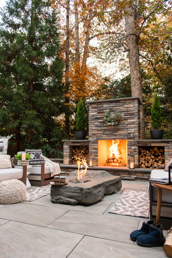 Diseño de patio moderno de tamaño medio en patio trasero con chimenea y adoquines de piedra natural