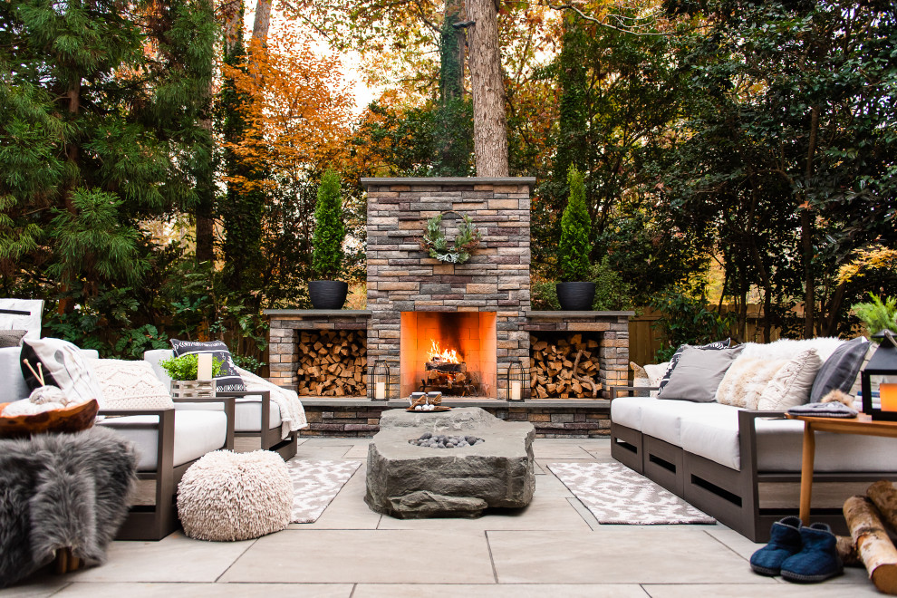 Ejemplo de patio moderno de tamaño medio en patio trasero con chimenea y adoquines de piedra natural